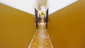 Un pasillo con piso estampado y paredes amarillas.
