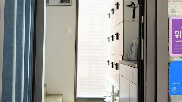 Habitación de hotel con puerta corrediza que da a un balcón, armario empotrado y vistas al exterior.