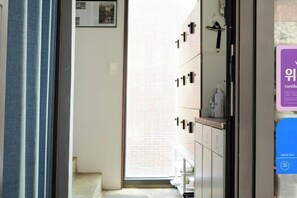 A hotel room with a sliding door leading to a balcony, a built-in wardrobe, and a view of the outside. - CATNAP GUESTHOUSE (Busan)