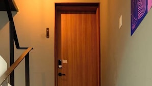 Una puerta de madera con un teclado electrónico y una pequeña señal en la pared.