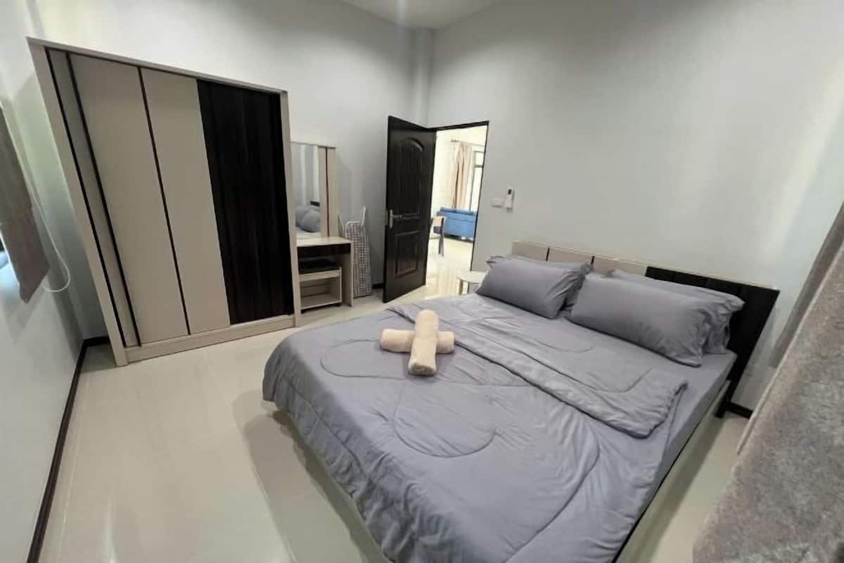 Un dormitorio con una cama, un armario y un escritorio.