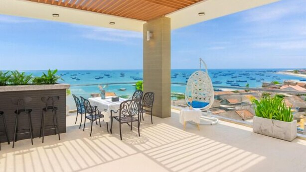 Une terrasse avec vue sur la mer, un espace bar et un coin repas.