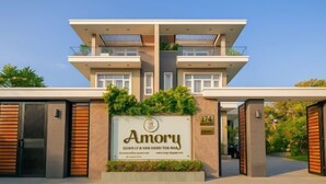 Un immeuble résidentiel moderne à plusieurs étages, avec une enseigne indiquant « Amory » et une plaque portant l’adresse « 174 ».