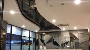 Un interior moderno con techo curvo, una escalera central y una recepción.