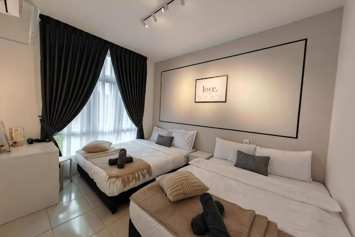 A hotel room with two beds, a desk, and a large window with curtains.