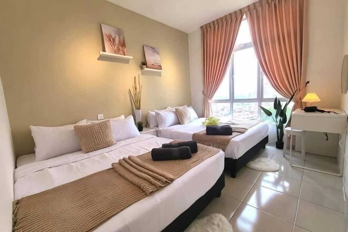 A hotel room with two beds, a desk, a chair, a lamp, and a large window with curtains.