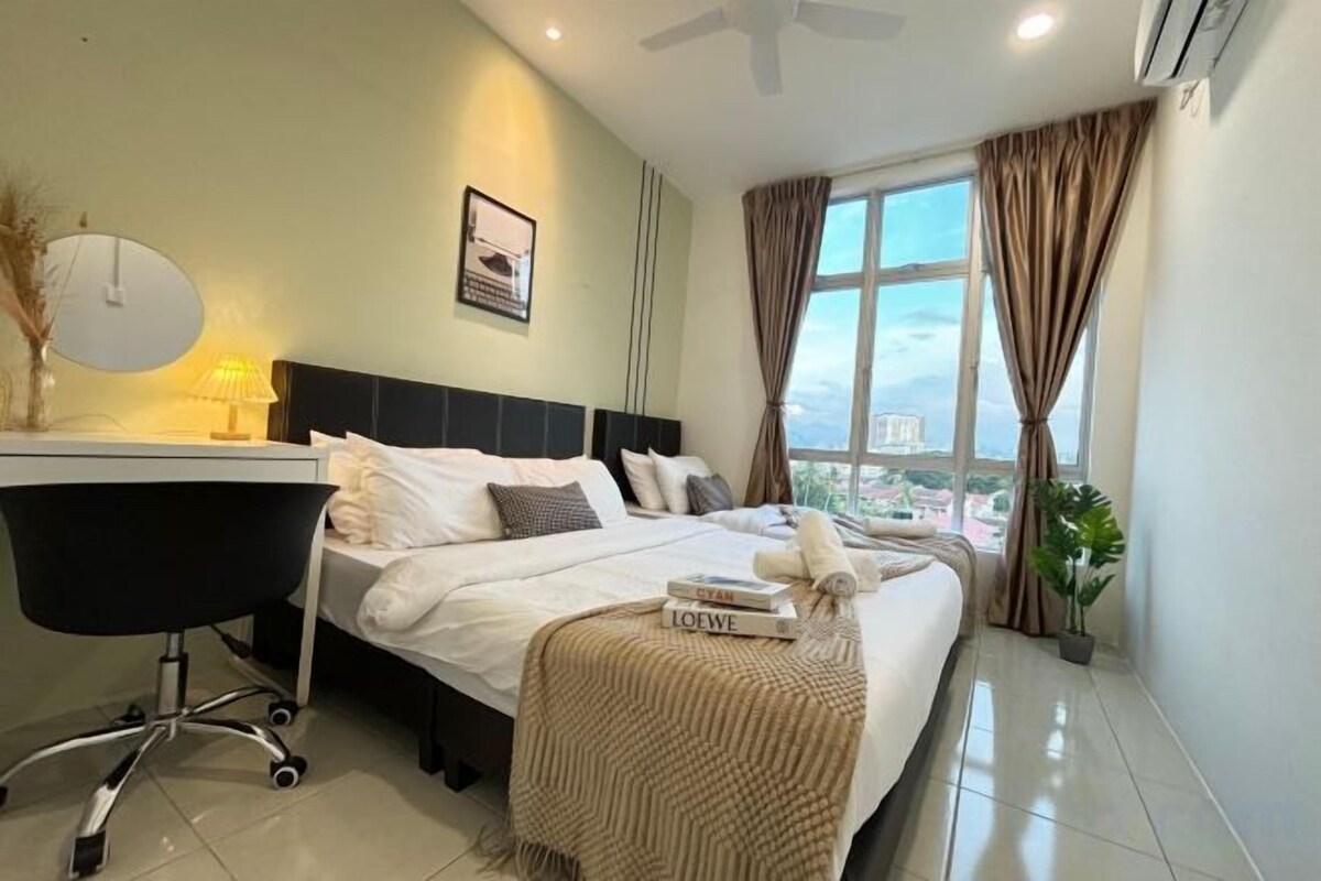 A hotel room with a bed, a desk, a chair, a window with curtains, and a view of the city.