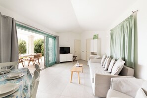 Departamento, 2 habitaciones, vista parcial al mar | Área de sala de estar | Televisión de 30 pulgadas con canales vía satélite 