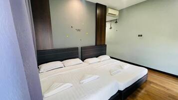 Una habitación de hotel moderna con una cama grande, suelo de madera y un equipo de aire acondicionado de pared.