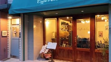 A storefront with a green awning and a sign that reads 'Café Astoré.'