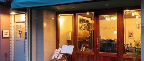 A storefront with a green awning and a sign that reads 'Café Astoré.'