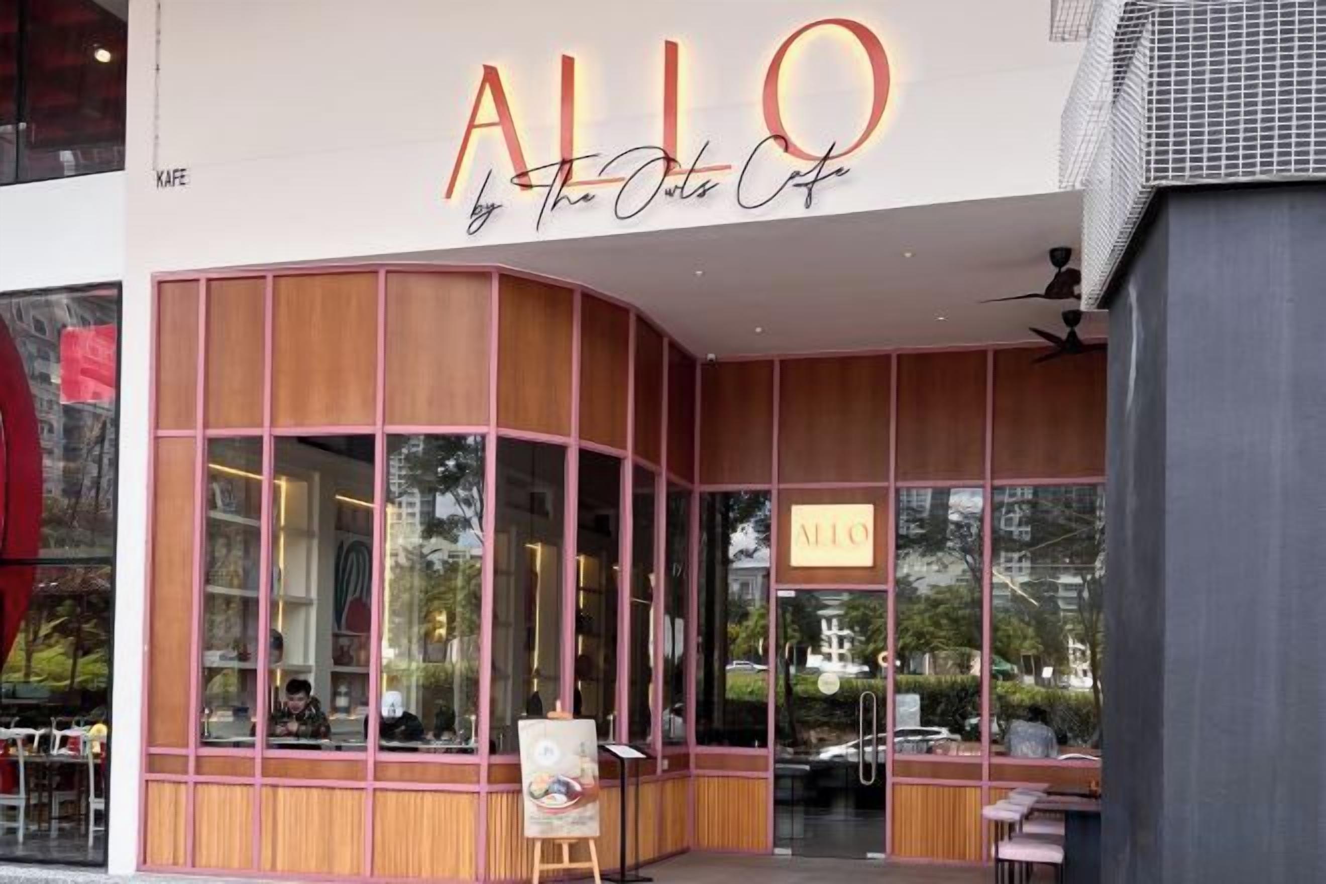 Un bâtiment moderne doté d’une grande façade en verre et d’une enseigne indiquant : « ALLO by The Olive Cafe ».