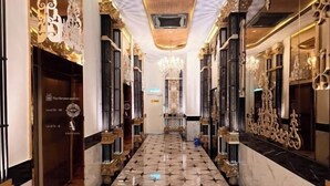 Un pasillo lujoso con decoraciones ornamentales, un candelabro y un piso de mármol.