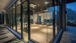 Ein modernes Fitnessstudio mit Trainingsgeräten und großen Fenstern.