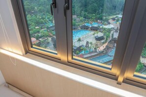 A window with a view of a resort area including a pool and traditional buildings. - Ipoh Tambun Lost World Sunway Onsen EasyU (Ulu Kinta)