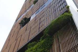A tall building with a modern design, featuring vertical lines and greenery. - Ceylonz Suites Bukit Bintang By ICEFLY (Kuala Lumpur)