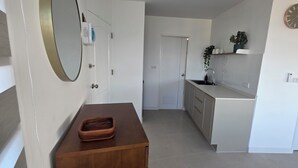 A modern kitchen with white cabinets, a wooden countertop, and a clock on the wall. - VIP Condominium GoldenEye - Hua Hin/Cha-am - TOP VIEW on beach/city/mountains (Tambon Cha-am)