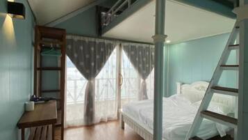 Un dormitorio con literas, un escritorio con silla y una escalera.