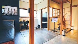 Un interior japonés tradicional con suelo de tatami, un área de descanso con esteras de tatami, una celosía japonesa y un pequeño santuario.