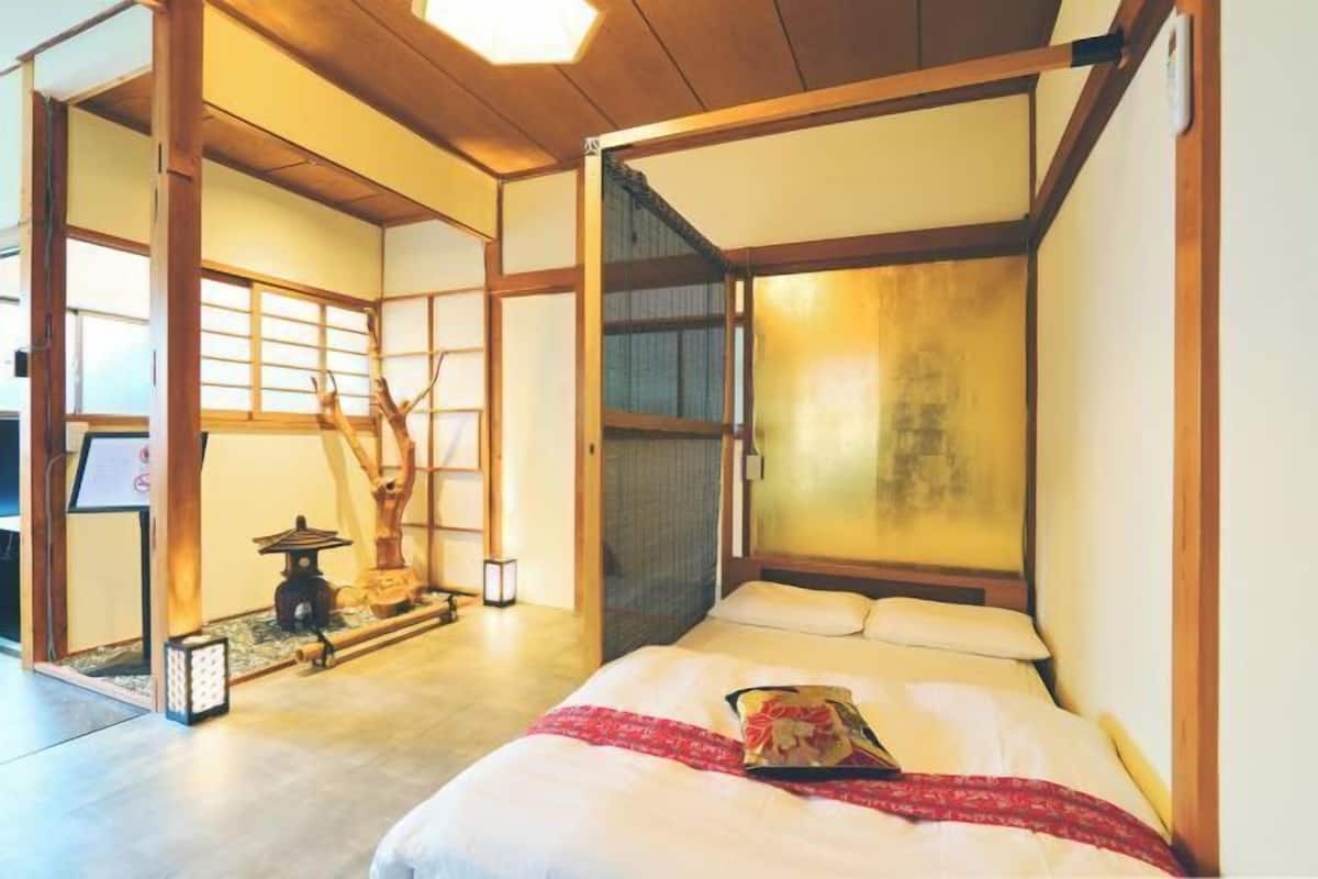 Een traditionele Japanse kamer met tatami vloerbedekking, een laag houten bed, schuifdeuren en een shoji scherm.