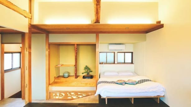 Un dormitorio con cama, un rincón de descanso y una ventana.