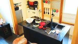 Una cocina compacta con una isla central, un refrigerador y un microondas.