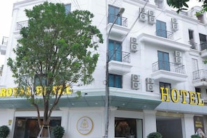 Een hotelgebouw met een bord waarop 'HOTEL ROYAL BANGKOK' staat.