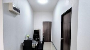 A narrow hallway with a dining table and chairs, a dark wooden door, and a wall-mounted air conditioning unit. - We House - Hangdong 2 (Hang Dong)