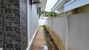 A narrow alleyway with a tiled wall on one side and a concrete wall on the other. - We House - Hangdong 2 (Hang Dong)