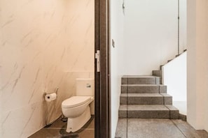 A bathroom with a toilet, a shower, and a marble wall. - INARA VILLA , Luxury Pool Villa Pattaya by Viola & Olivia (Pattaya)