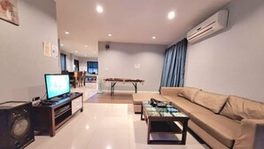 Una sala de estar moderna con un sofá, una mesa de centro, un televisor y un sistema de sonido.