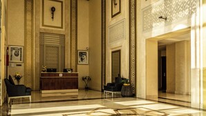 A lobby with a reception desk, seating area, and decorative wall patterns.