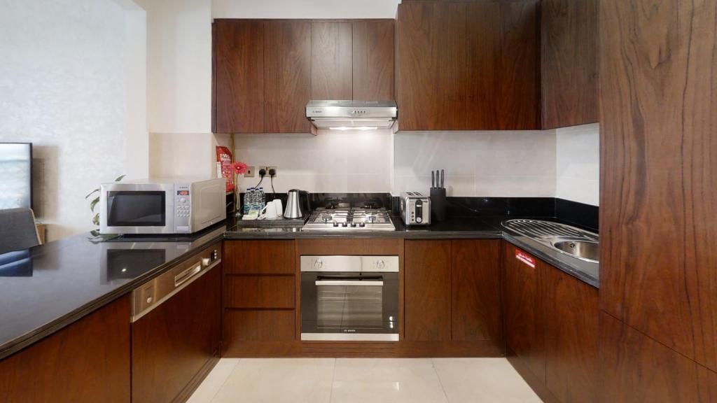 Una cocina compacta equipada con microondas, tostadora, estufa, horno y armarios de madera.