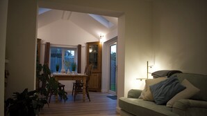 Ein gemütliches Wohnzimmer mit einer Couch, einem Esstisch mit Stühlen und einem großen Fenster.