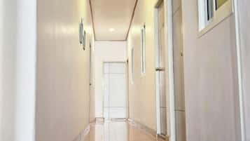 A corridor with doors on both sides, leading to rooms.