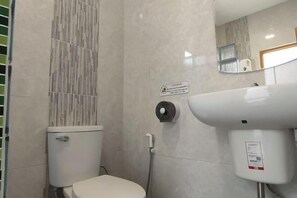 A bathroom with a toilet, a hand dryer, and a sink. - Khunnampheung Apartment (Sakon Nakhon)