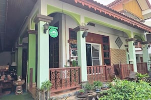 Un edificio tradicional con fachada verde, balcones de madera y un letrero que indica un restaurante.