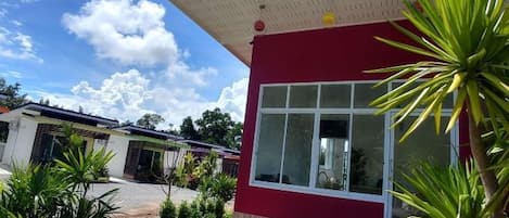 A red building with a large window and a covered porch.