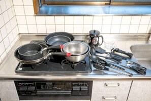 A kitchen with a stove, frying pans, a coffee maker, and various utensils. - 8 min by train from Ikebukuro Station, 18 min from Shinjuku Station (Tokyo)