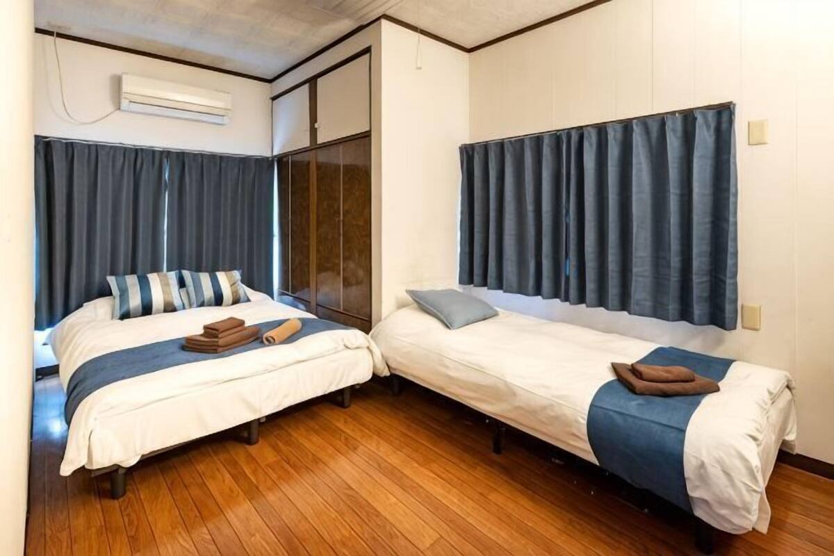 Two single beds with headboards, a wooden floor, and a sliding door.