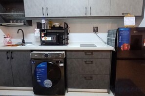 Una cocina con lavavajillas, microondas y refrigerador.