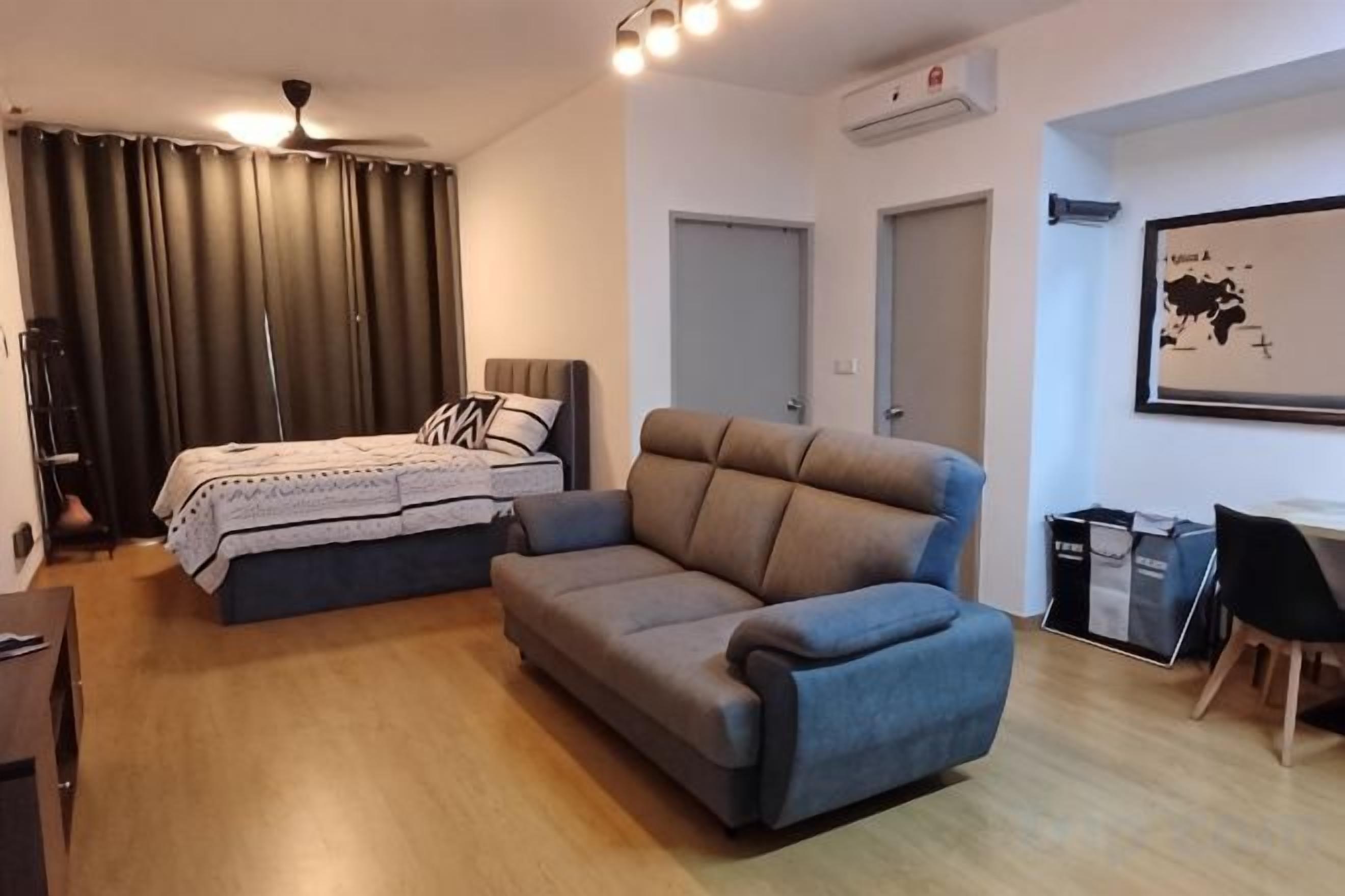 A room with a bed, a sofa, a desk, and a chair.