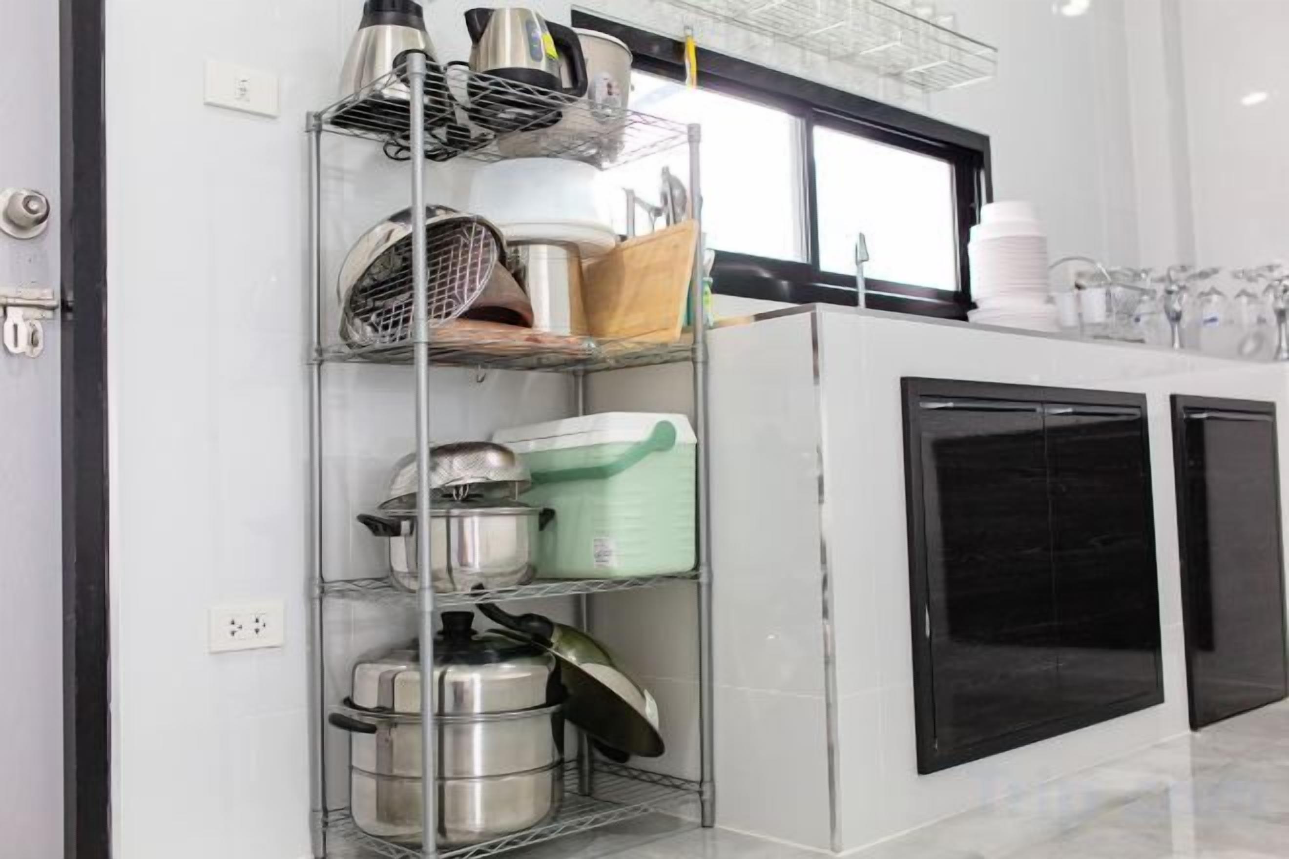 A kitchen with stainless steel appliances, a window above the sink, and a black cabinet below.