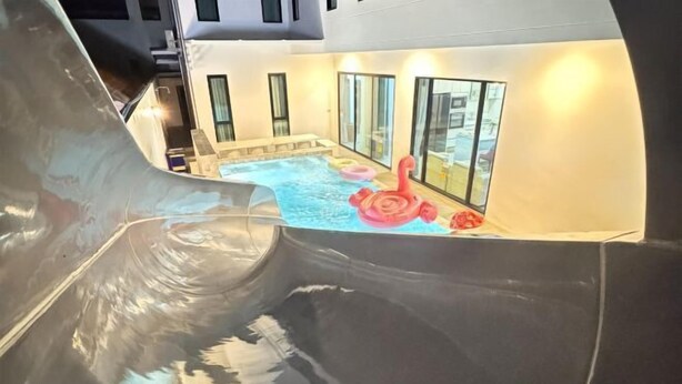 A pool area with a hot tub, inflatable rings, and a slide. - The White House Pool Villa Pattaya (Pattaya)