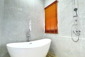 A bathroom with a freestanding bathtub, a shower, and a window with blinds. - The White House Pool Villa Pattaya (Pattaya)