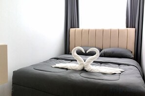 A bed with a headboard, two pillows, and a towel arranged in a heart shape. - The White House Pool Villa Pattaya (Pattaya)
