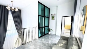 A modern living room with a marble floor, a sofa, a staircase, and a large window with curtains. - The White House Pool Villa Pattaya (Pattaya)