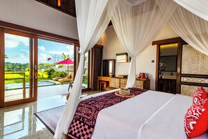 Quarto com uma cama grande, escrivaninha e vista para a piscina e jardim.