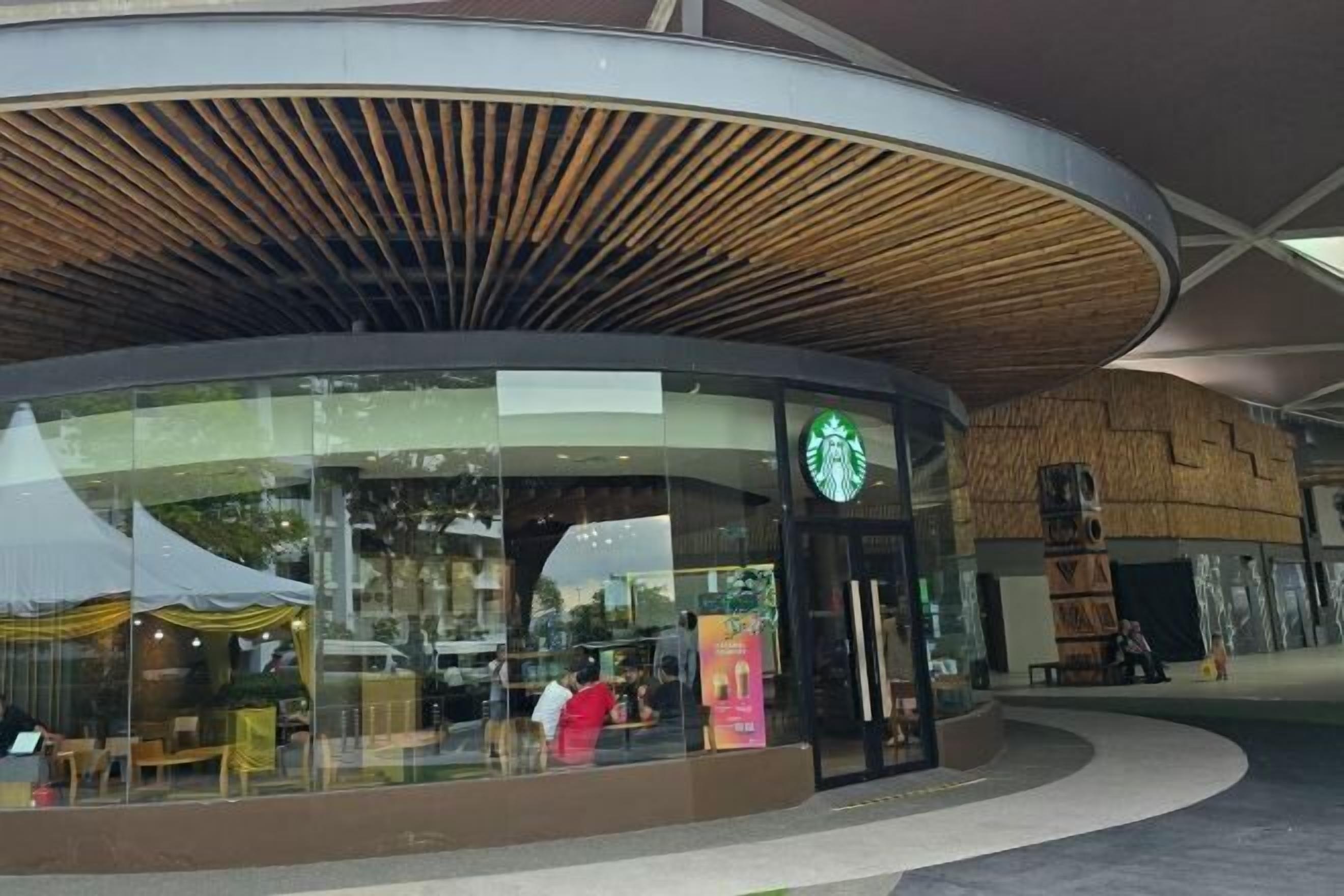 A Starbucks with a modern design, large windows, and a curved entrance.
