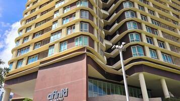 A multi-story hotel with a curved facade, large windows, and a prominent entrance.